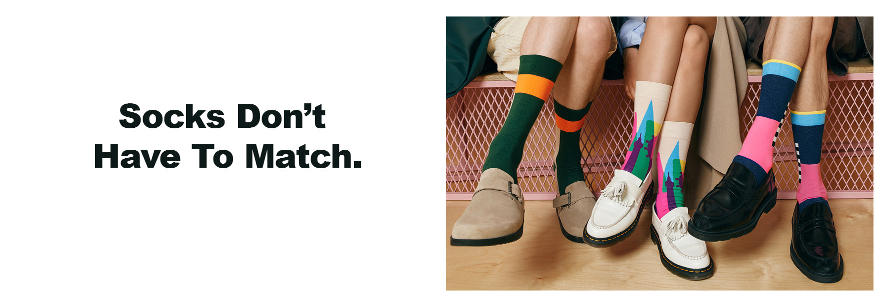 Colorful socks worn by people sitting on a bench with text 'Socks Don't Have To Match'.